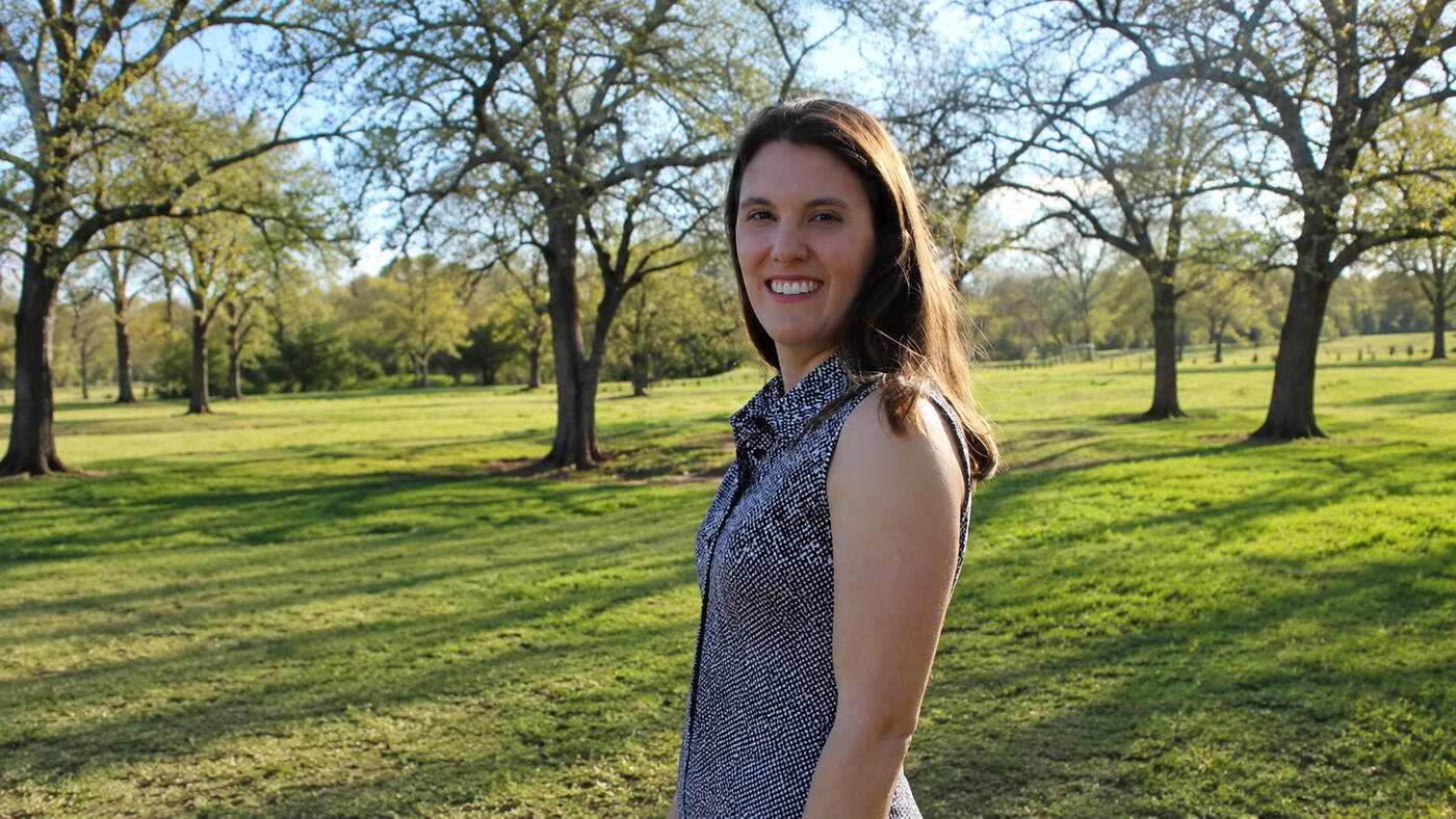 Caroline standing in a sunlit park